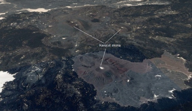 Gambar 6. Citra satelit Landsat dalam warna nyata untuk salah satu lokasi retakan yang menjadi sumber Letusan Madinah 1256. Nampak sejumlah kerucu skoria (cinder cone) yang dikelilingi bebatuan berwarna gelap (yang adalah endapan lava basaltik). Sumber: Google Earth, 2014. 