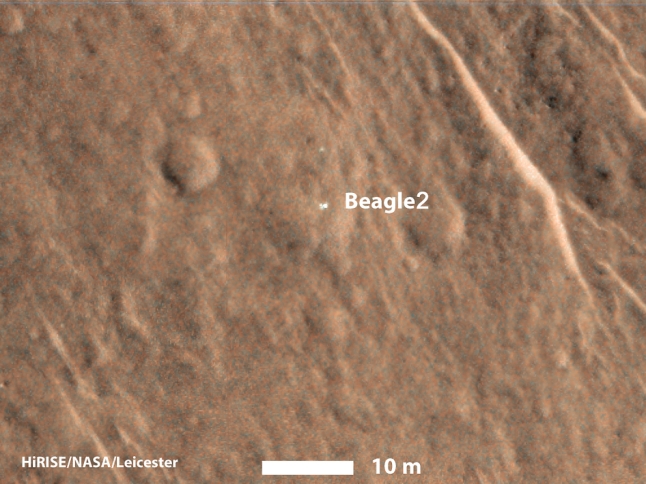Gambar 5. Wahana pendarat Beagle 2 dalam citra Mars Reconaissance Orbiter yang diperbesar. Nampak jelas Beagle 2 tetap utuh namun hanya dua "daun" yang mekar dari tubuhnya. Sementara tiga "daun" sisanya tak terlihat. Sumber: NASA, 2015. 