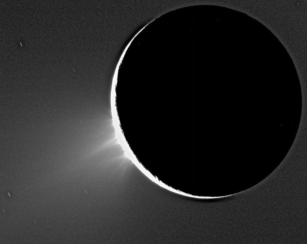Gambar 6. Enceladus dalam fase sabit dan semburan material vulkanisme dingin produk letusan gunung berapi aktif di dekat kutub selatannya, seperti diabadikan wahana Cassini pada 2005. Sumber: NASA. 2005. 