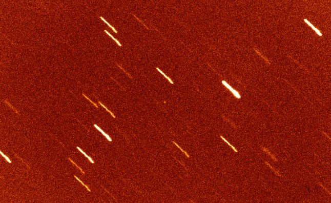 Gambar 2. Asteroid Oumuamua (bintik putih di tengah foto), diamati dengan teleskop William Herschell Observatorium La Palma, Canary (Spanyol). Garis-garis putih diagonal merupakan jejak bintang-bintang di latar belakang seiring teleskop ‘dikunci’ ke posisi asteroid. Inilah benda langit pertama yang dipastikan berasal dari luar tata surya. Sumber: Observatorium La Palma, 2017.